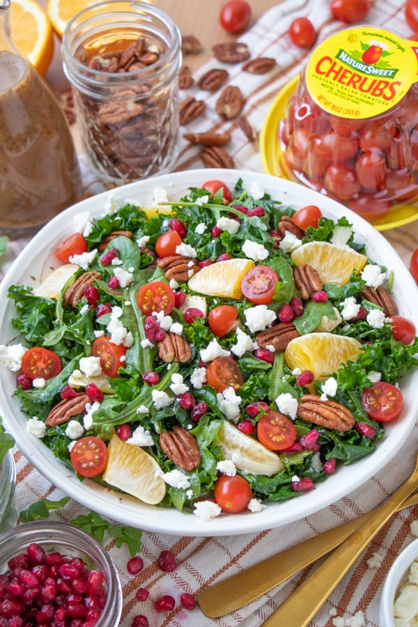 Kale salad with pecans, oranges, tomatoes, feta and pomegranate seeds.