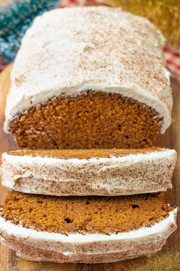 Close up of gingerbread cake with two slices in front.