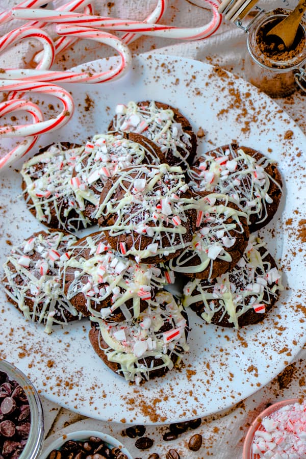 Peppermint mocha cookies on a white plate with candy canes around.