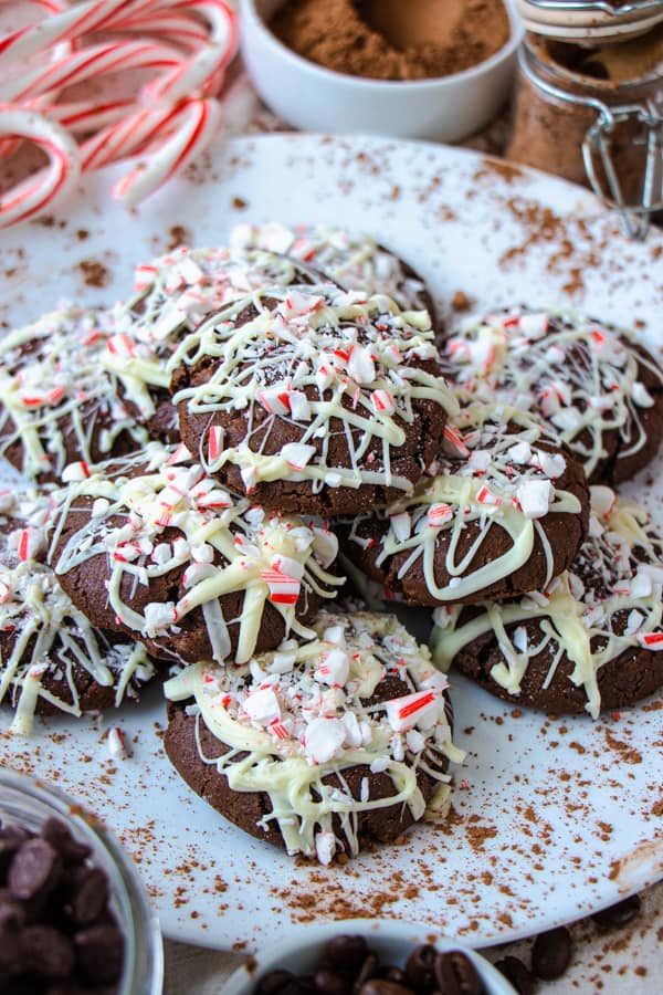 Side angle of chocolate cookies on a white plate with decorations.