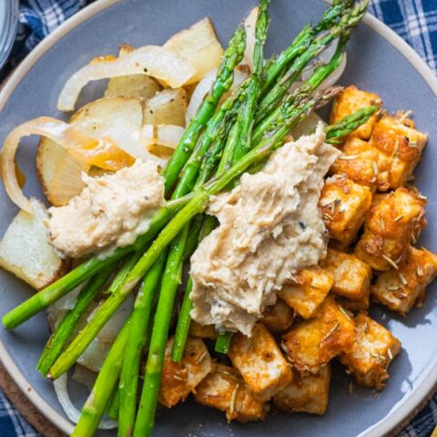 Tofu, asparagus and potatoes on plate.