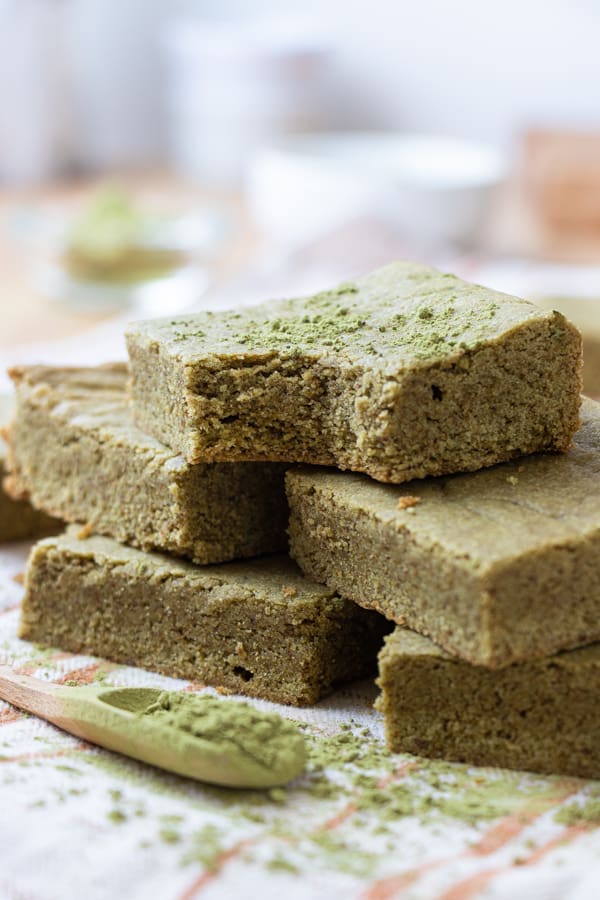 Brownies stacked with matcha powder.