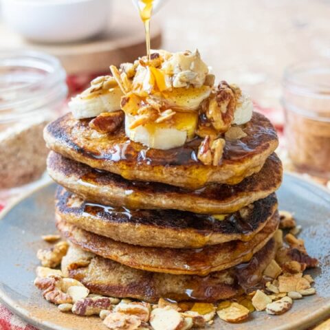 Pouring syrup on pancakes.